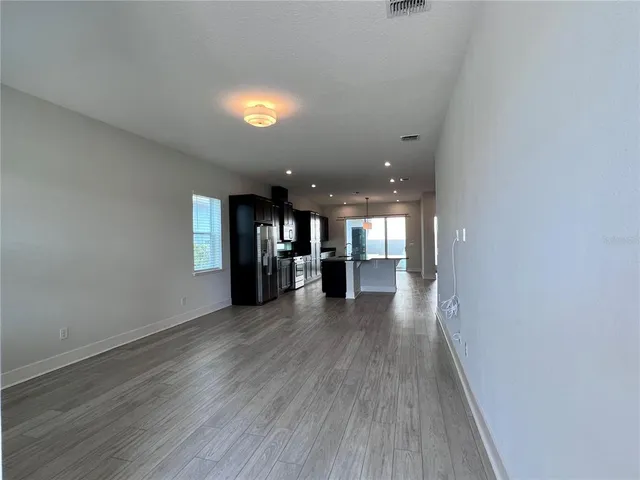 a kitchen with stainless steel appliances granite countertop a refrigerator a stove a sink and a oven with wooden floor