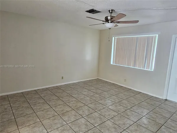 a view of a room with window and a chandelier fan