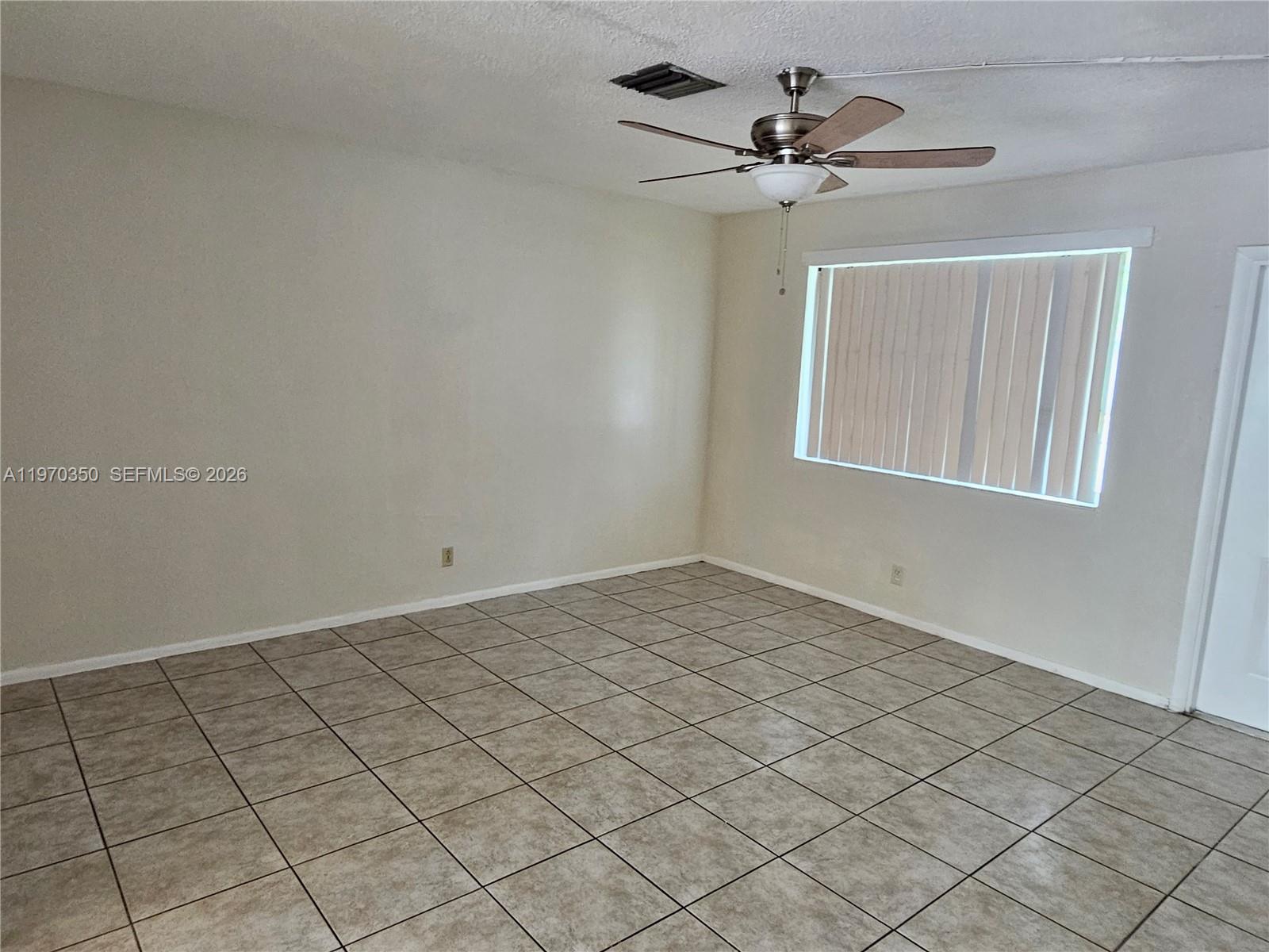 5820 Northwest 19th Street, Unit B Sunrise, FL 33313 - Photo 4 of 15 a view of a room with window and a chandelier fan