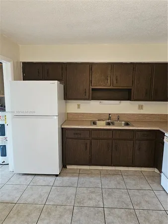 a kitchen with a cabinets and a refrigerator