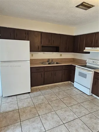 a kitchen with stainless steel appliances a sink and a refrigerator