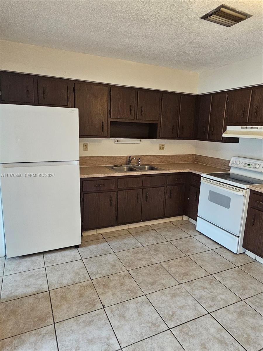 5820 Northwest 19th Street, Unit B Sunrise, FL 33313 - Photo 7 of 15 a kitchen with stainless steel appliances a sink and a refrigerator