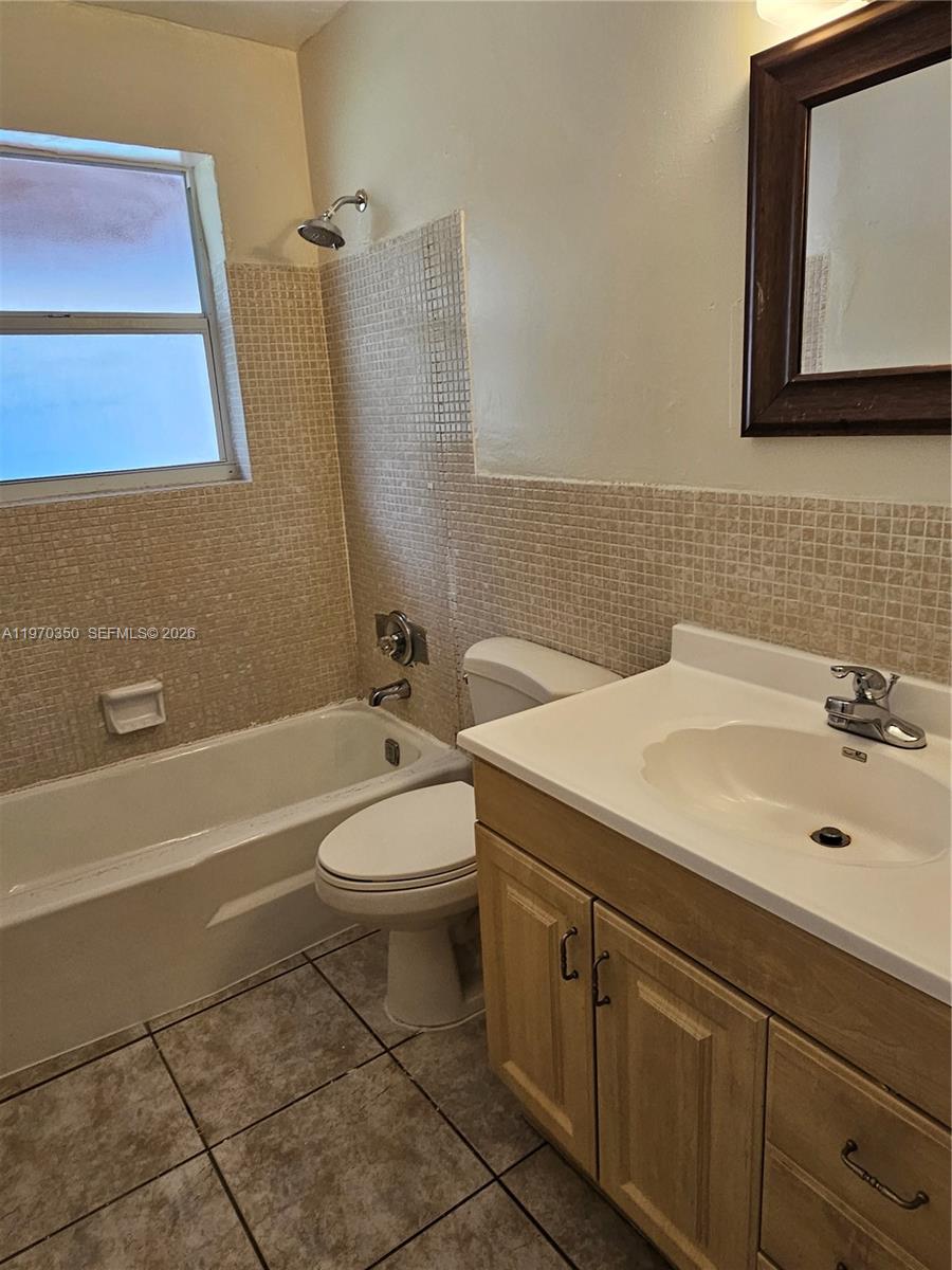 5820 Northwest 19th Street, Unit B Sunrise, FL 33313 - Photo 9 of 15 a bathroom with a toilet a sink and mirror
