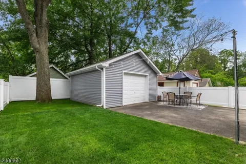 a view of a backyard with table and chairs and a large tree