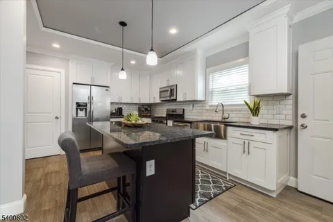 a kitchen with stainless steel appliances granite countertop a stove a sink a refrigerator and a refrigerator