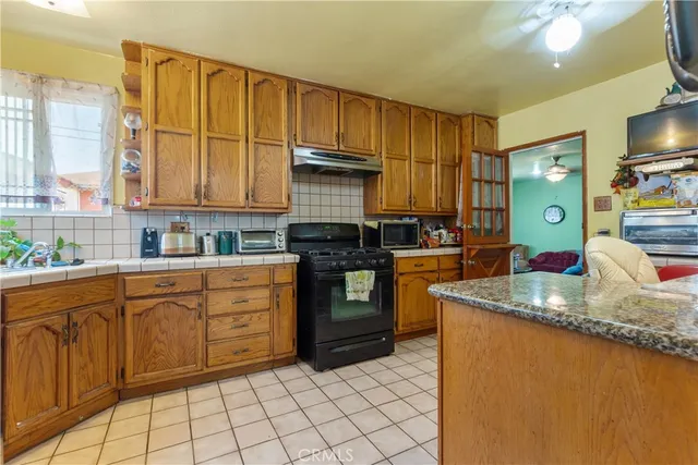 a kitchen with granite countertop a sink stainless steel appliances and cabinets