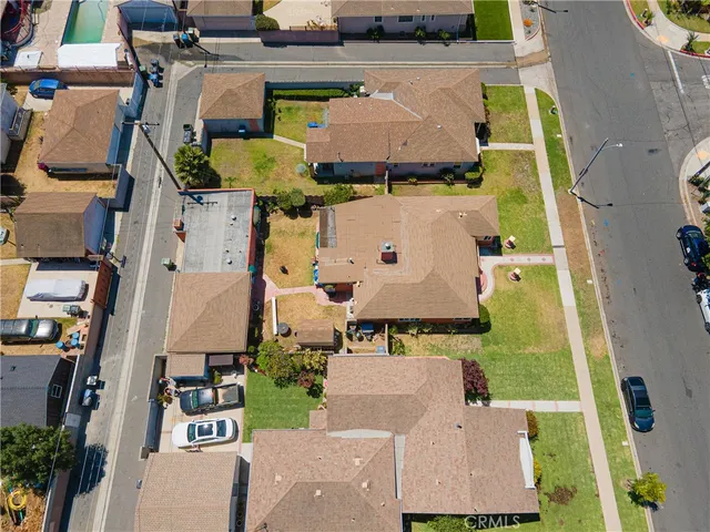 an aerial view of residential houses with outdoor space and parking
