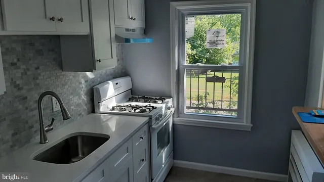 a kitchen with a sink and a stove next to a window