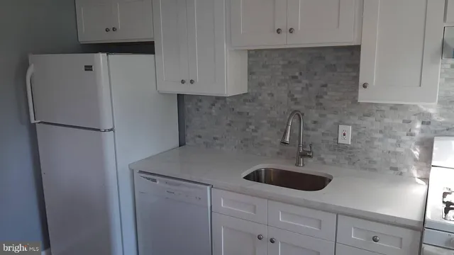 a kitchen with stainless steel appliances white cabinets and a refrigerator