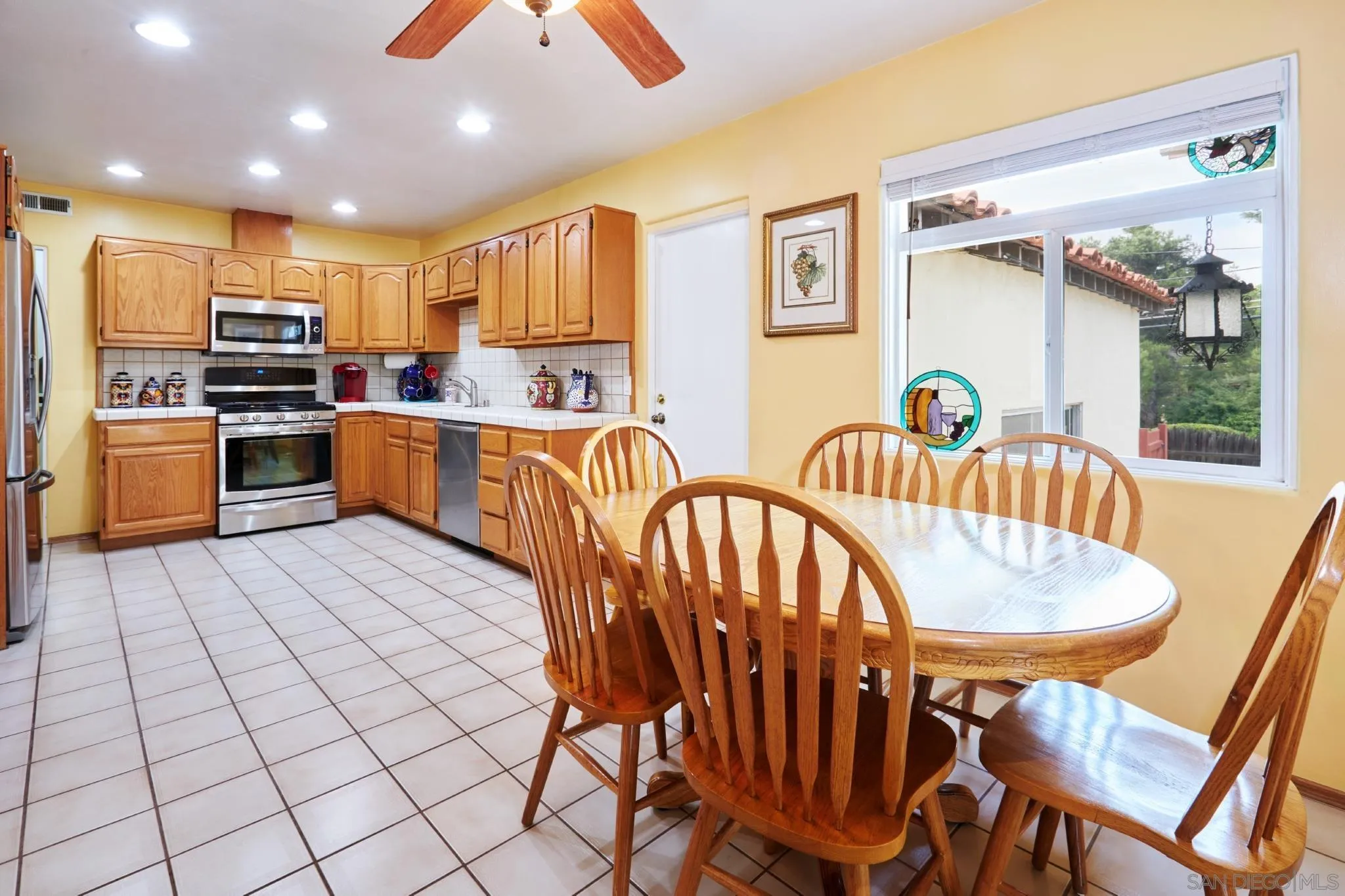 4437 Upland Street La Mesa, CA 91941 - Photo 13 of 24 a kitchen with stainless steel appliances kitchen island granite countertop a dining table chairs sink and granite counter tops