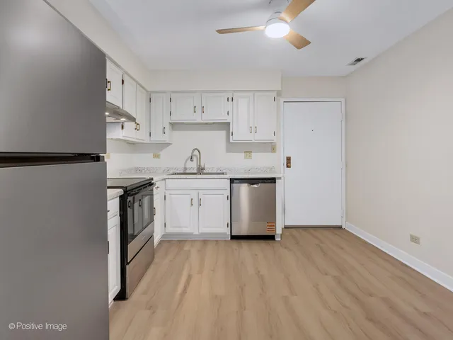 a kitchen with cabinets a sink and white appliances