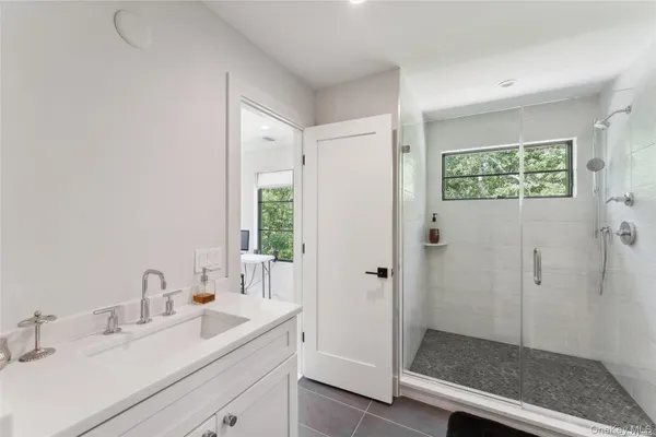 a bathroom with a shower sink and mirror