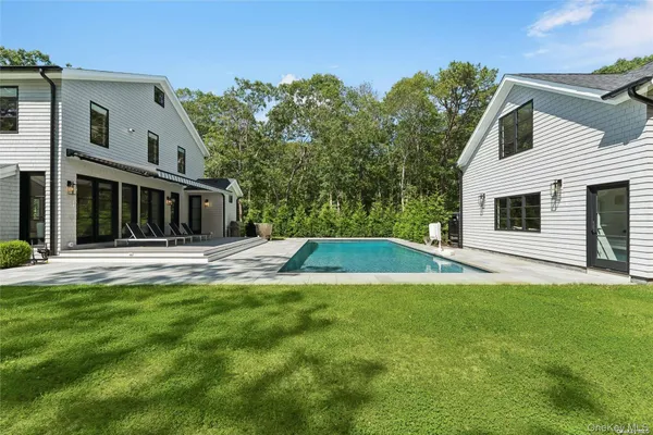a view of house with yard and swimming pool