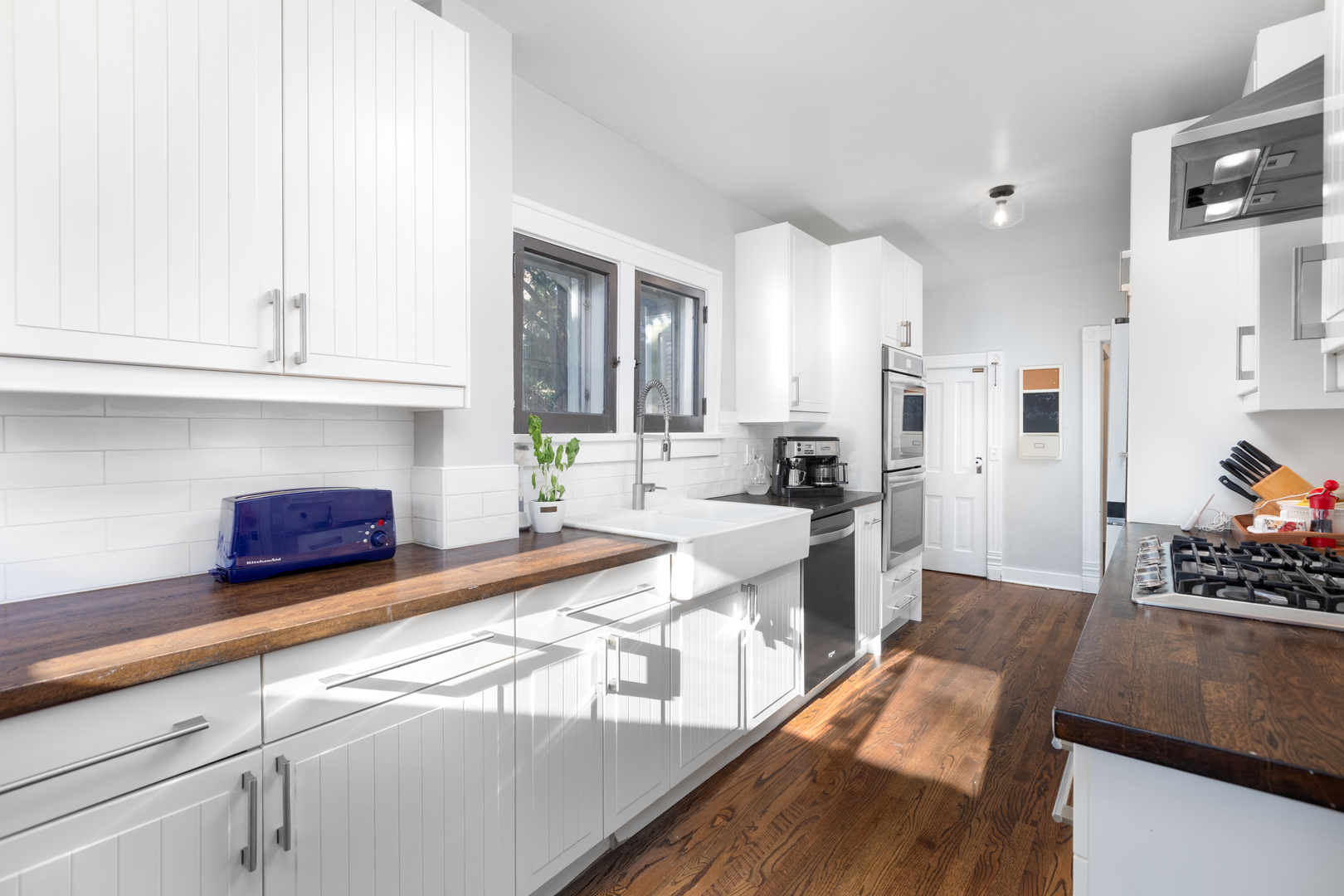 105 South Wright Street Naperville, IL 60540 - Photo 23 of 47 a kitchen with stainless steel appliances kitchen island granite countertop a refrigerator a stove a sink dishwasher and white cabinets with wooden floor