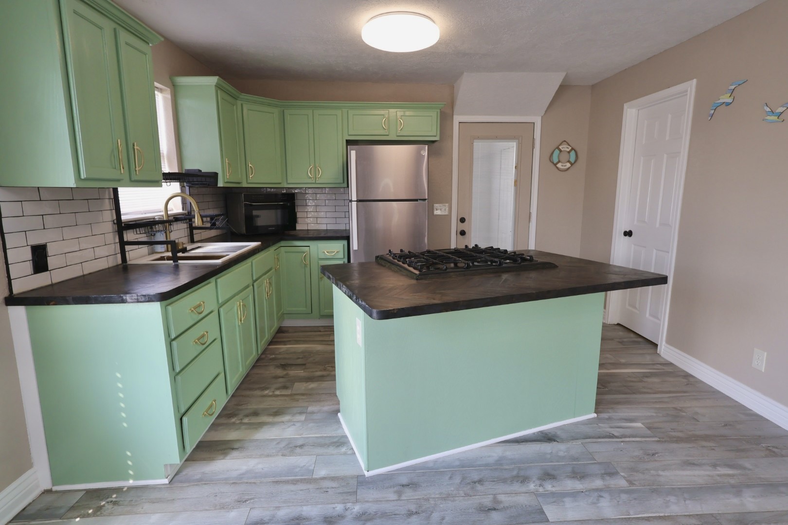 642 5th Street Dickinson, TX 77539 - Photo 3 of 20 Bright and spacious kitchen featuring a central island, ample cabinet storage, sleek countertops, and modern appliances—perfect for both everyday living and entertaining.