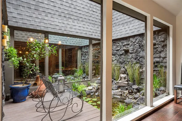 a view of a porch with chairs and potted plants