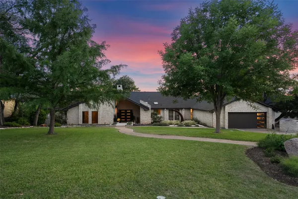 a front view of a house with a yard and trees