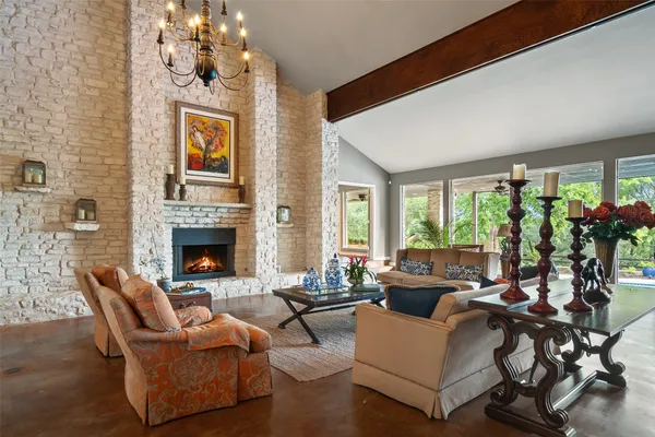 a living room with furniture a chandelier and a fireplace