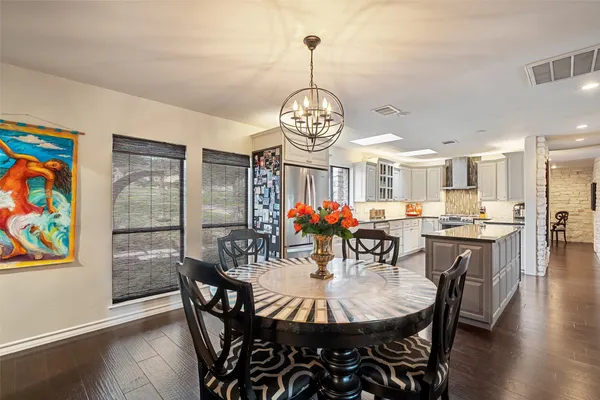 a view of a dining room with furniture a chandelier and wooden floor