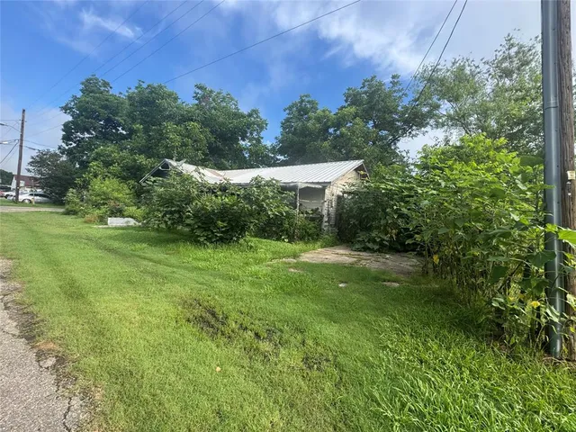 a view of a grassy field with trees in the background