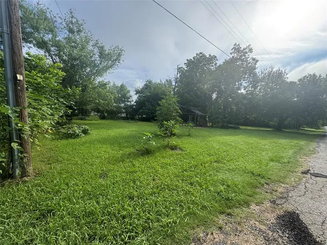 a view of a big yard with a house in the background