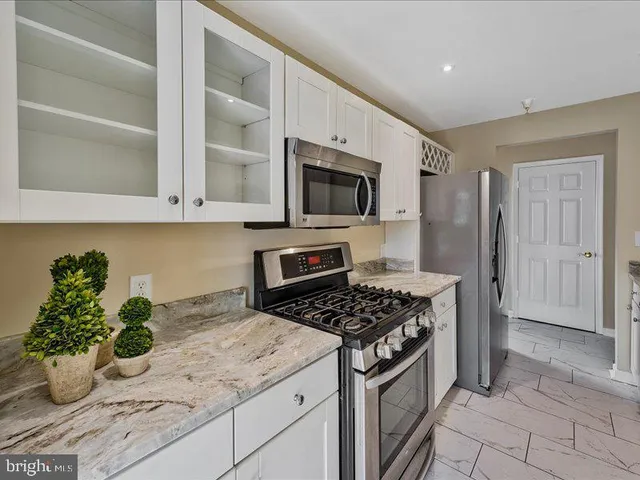 a kitchen with granite countertop a sink stainless steel appliances and cabinets