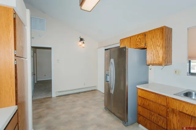 a kitchen with stainless steel appliances granite countertop a refrigerator and a stove top oven