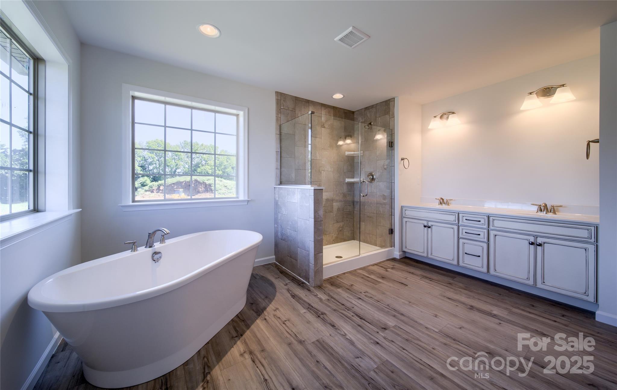 42 Watercourse Way, Unit DEVONSHIRE Belmont, NC 28012 - Photo 45 of 48 a spacious bathroom with a double vanity sink a mirror and a bathtub