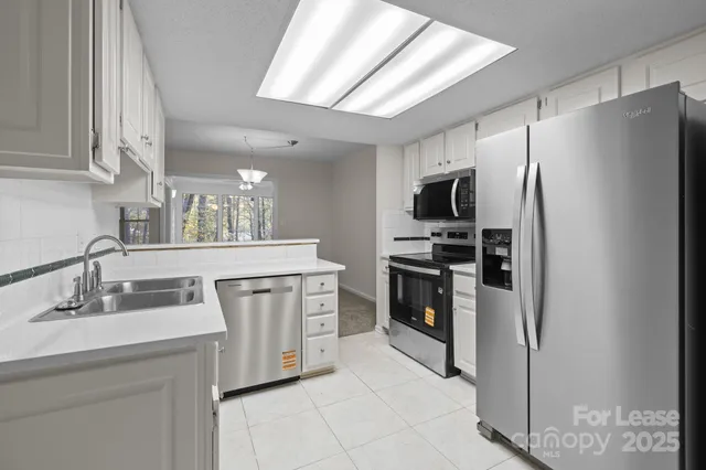 a kitchen with white cabinets appliances and sink