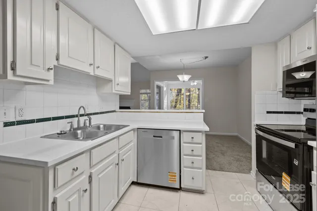 a kitchen with stainless steel appliances a stove microwave and refrigerator