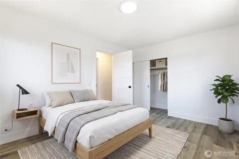 a bedroom with a bed and a potted plant