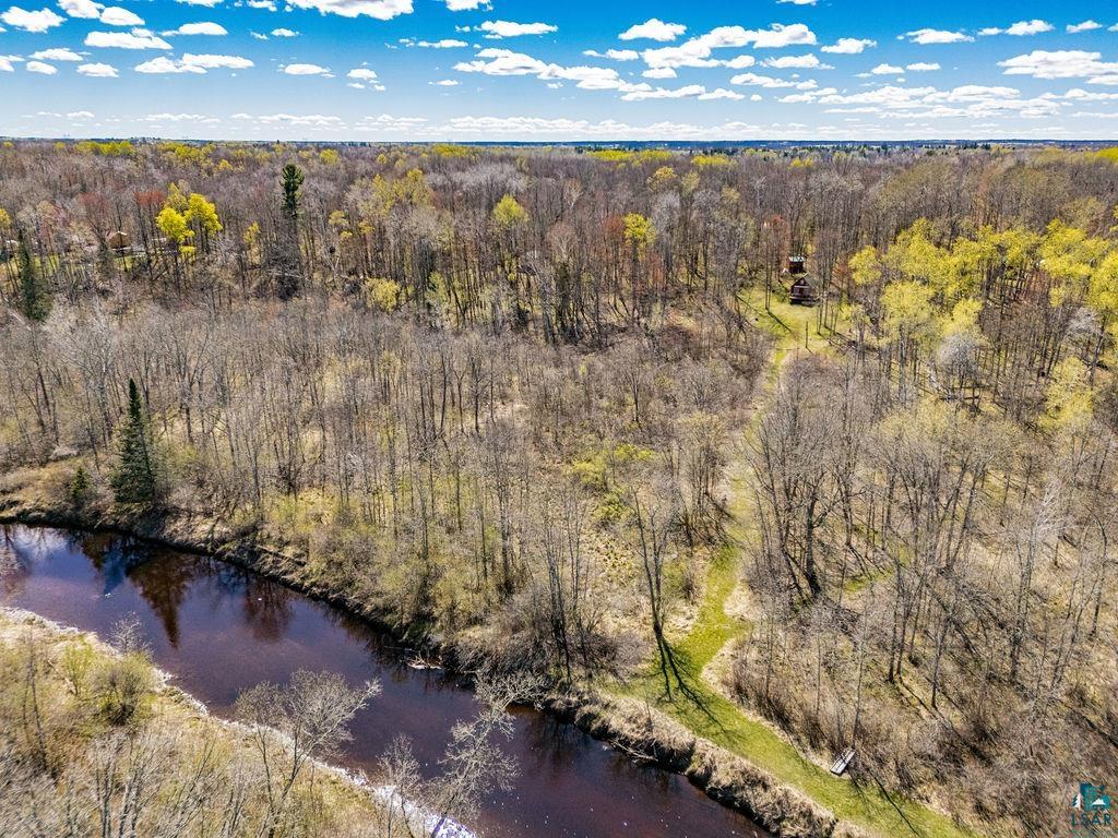 20663 Hardwood Loop Finlayson, MN 55735 - Photo 29 of 36 Wooded acreage featuring a river frontage, a clear path through the trees, and distant structures