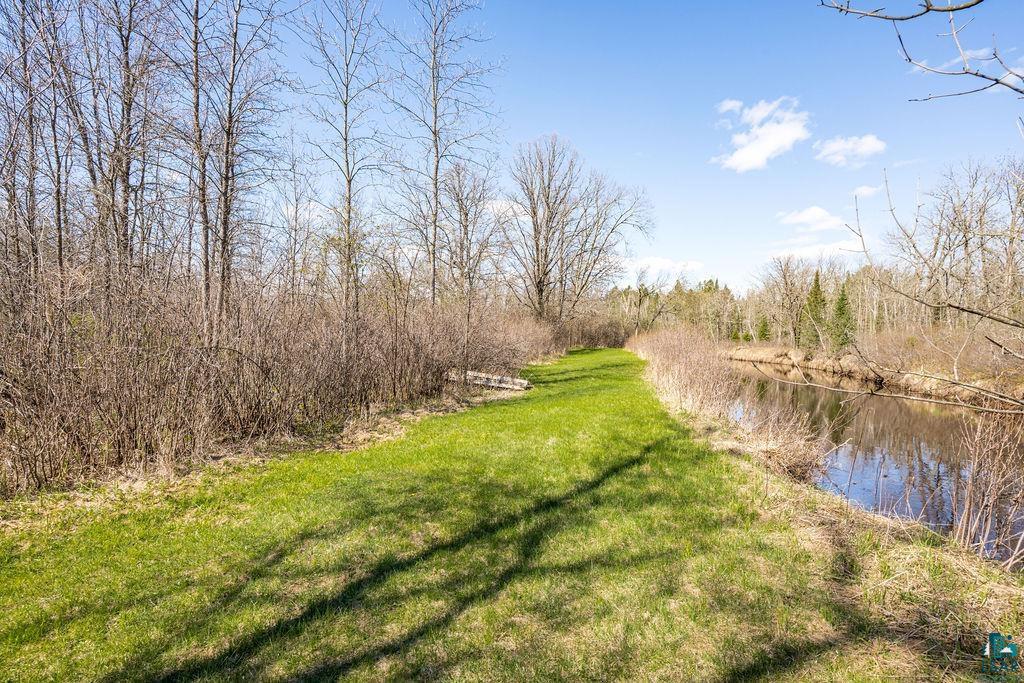 20663 Hardwood Loop Finlayson, MN 55735 - Photo 30 of 36 Expansive green space featuring a natural water body, mature deciduous trees, and varied shrubbery along the perimeter