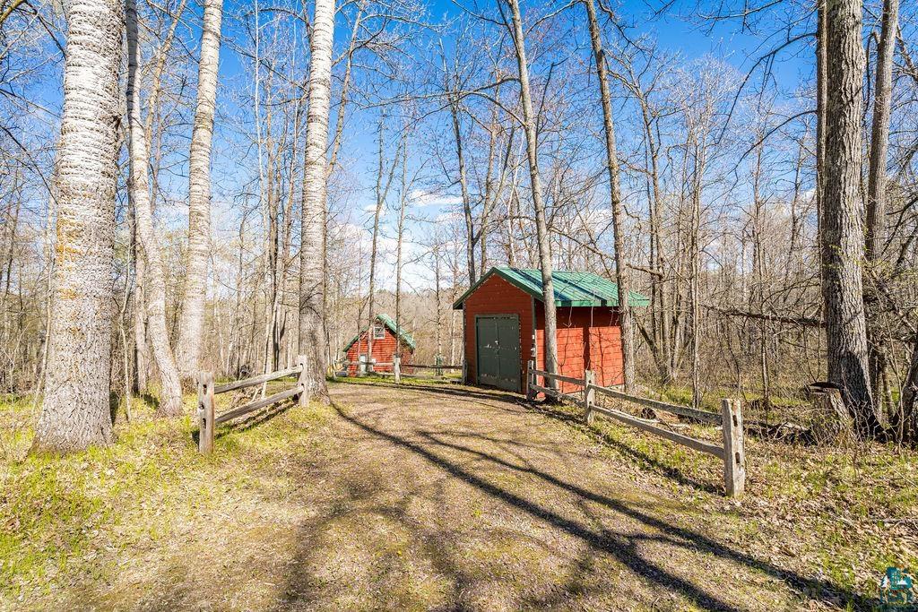 20663 Hardwood Loop Finlayson, MN 55735 - Photo 36 of 36 Wooded setting featuring a red outbuilding with a green roof and a gravel path