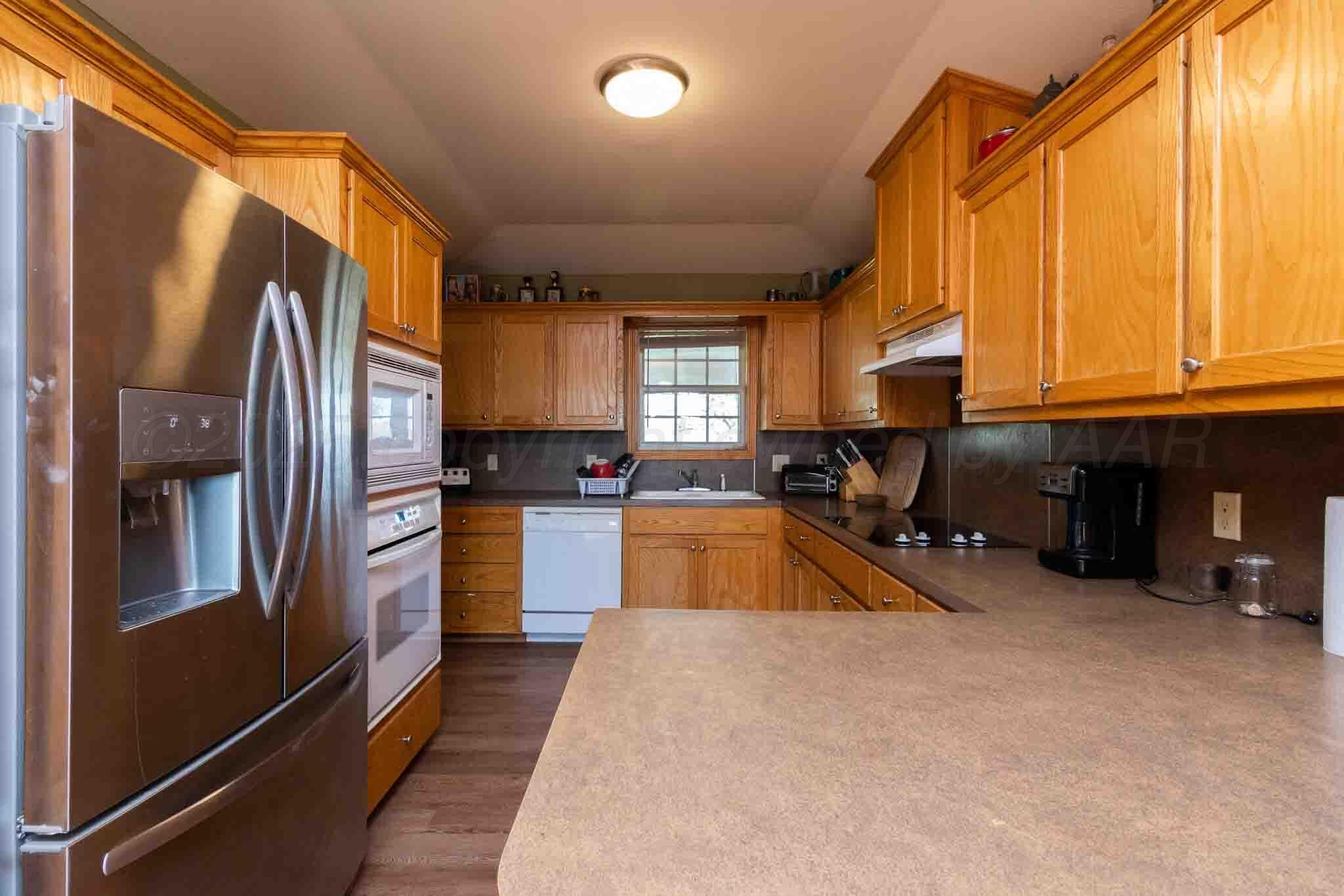 Reeves Ranch Memphis, TX 79245 - Photo 101 of 144 a kitchen with stainless steel appliances granite countertop a refrigerator a stove and a sink with large window