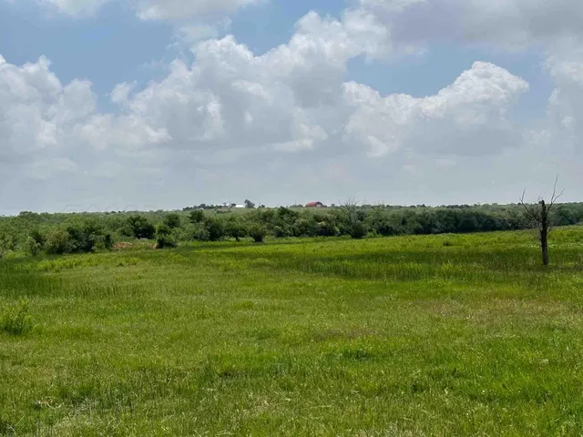 a kitchen with stainless steel appliances granite countertop a refrigerator a stove and a sink with large window