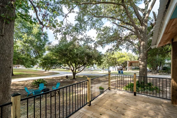 a view of a porch with wooden floor and wooden fence