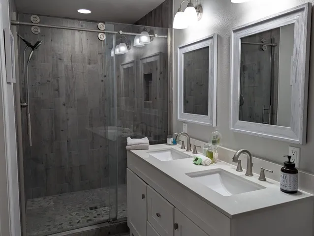a bathroom with a granite countertop sink a toilet and mirror
