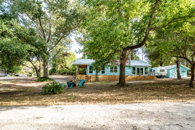 a view of a house with a big yard and large trees