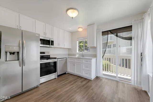 a kitchen with granite countertop a refrigerator stove and sink