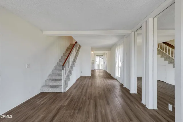 a view of a hallway with wooden floor and staircase