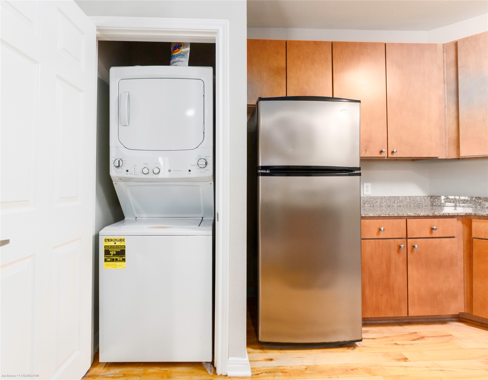 2502 Leon Street, Unit 305 Austin, TX 78705 - Photo 11 of 26 Laundry area with stacked washer and clothes dryer and light wood-type flooring