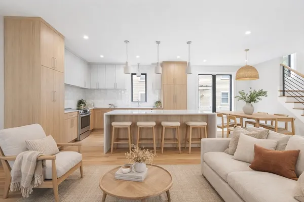 a living room with furniture kitchen view and a wooden floor