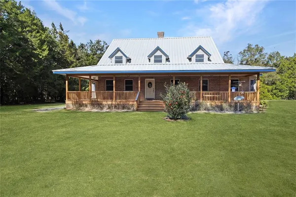 a view of a house with garden and a yard