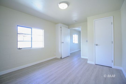 801 South Allen Street Ridgecrest, CA 93555 - Photo 12 of 17 an empty room with wooden floor and windows