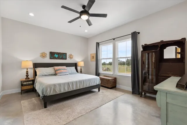 a bedroom with a large bed and a chandelier fan