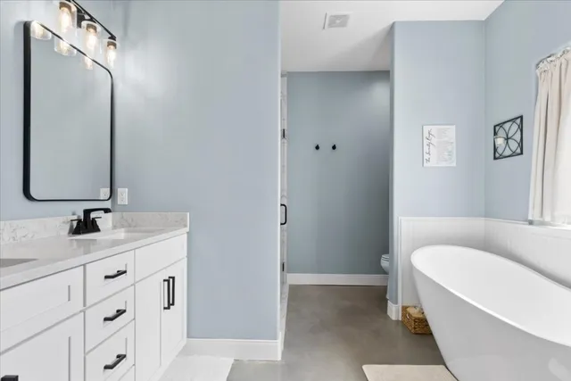 a bathroom with a tub sink and mirror