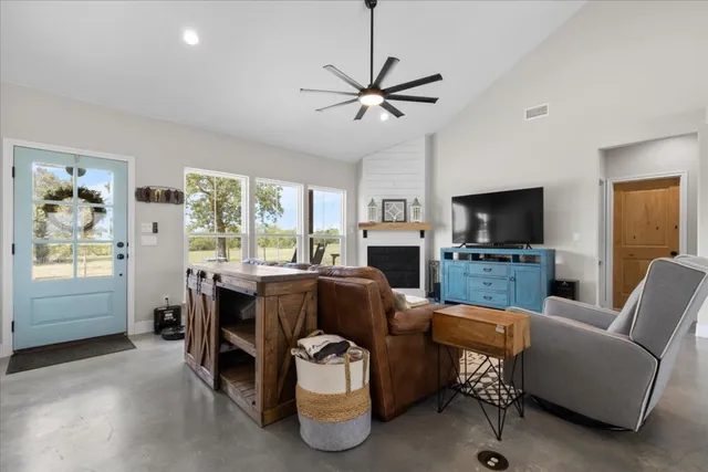 a living room with furniture a flat screen tv and a window