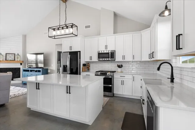 a kitchen with stainless steel appliances granite countertop a white cabinets a stove a sink and dishwasher