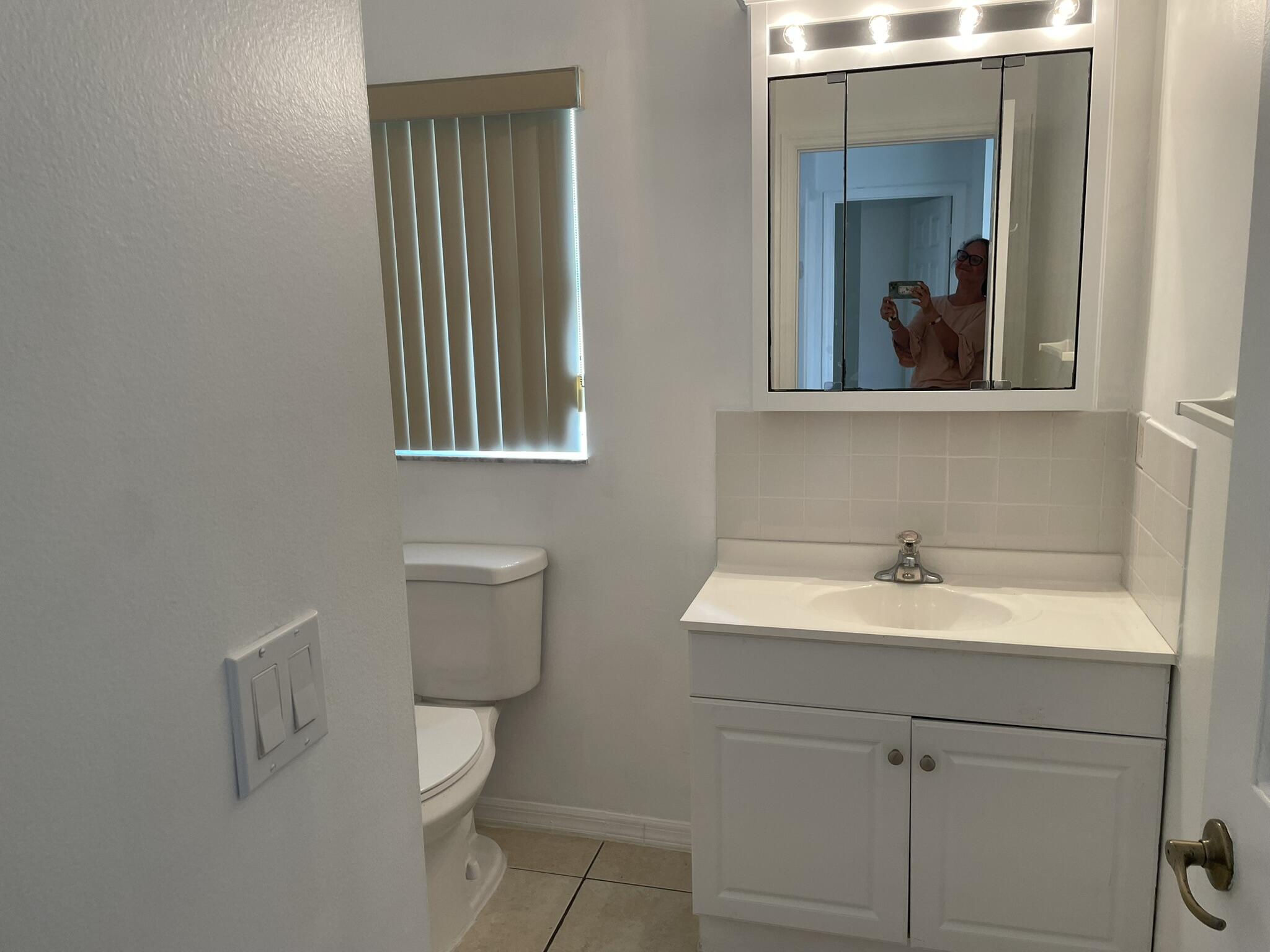 4448 Northwest Bighorn Avenue Port St. Lucie, FL 34983 - Photo 12 of 19 a bathroom with a toilet sink and mirror